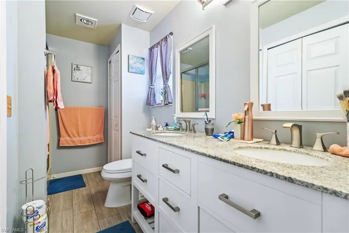 Bathroom featuring double vanity, wood tiled floors, and a closet
