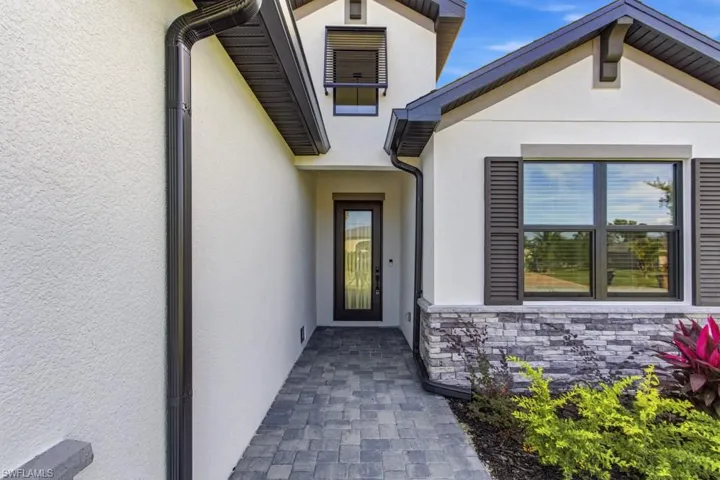 Doorway to property with stucco siding and stone siding
