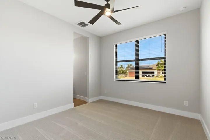 Spare room with light carpet and ceiling fan