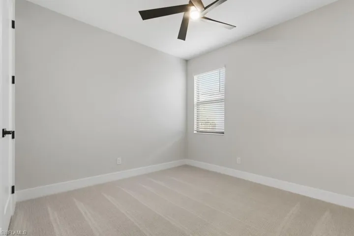 Spare room with light carpet and a ceiling fan