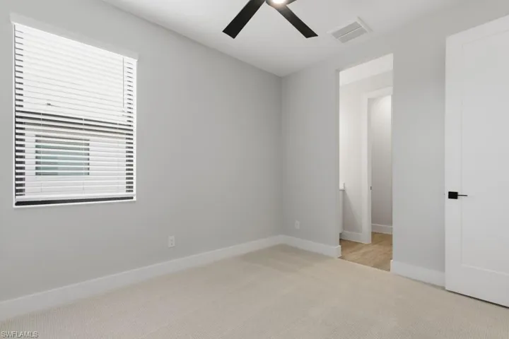 Unfurnished bedroom featuring ceiling fan and light colored carpet