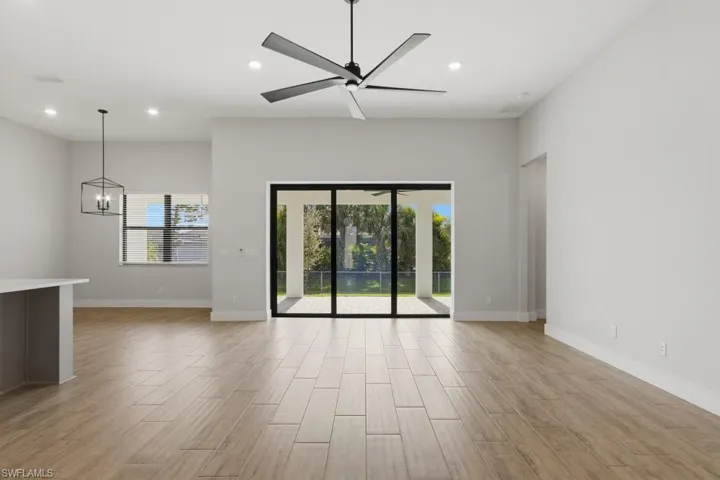 Unfurnished room with wood finish floors, recessed lighting, a chandelier, and a ceiling fan