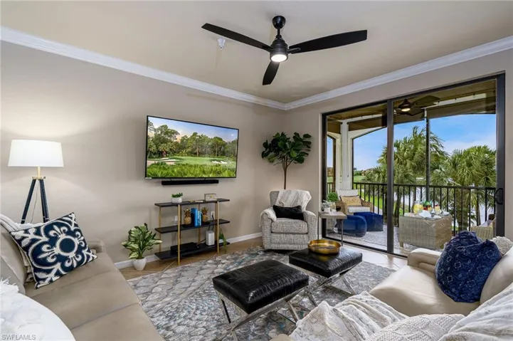 Spacious living area featuring neutral wall tones, crown molding, a ceiling fan with integrated lighting, and direct access to an enclosed lanai through sliding glass doors