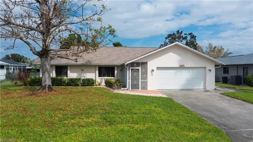 Ranch-style house featuring a front lawn, central AC unit, and a garage