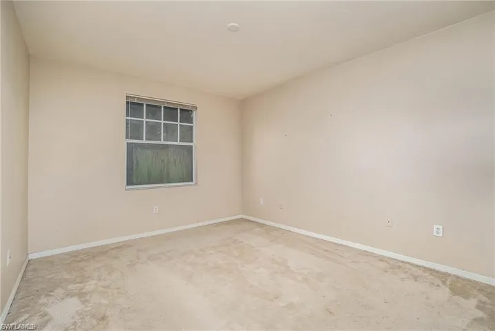 Carpeted spare room with baseboards