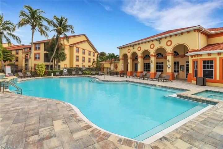 Pool with a patio, a community hot tub, and fence
