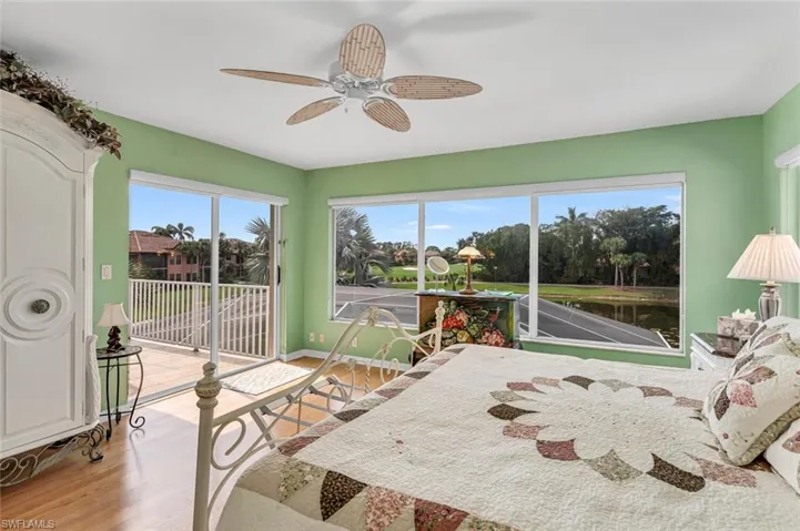 Bedroom with access to outside, light hardwood / wood-style floors, ceiling fan, and a water view