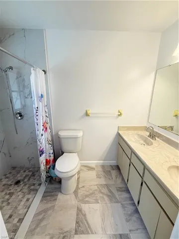 Full bathroom featuring a tiled shower, double vanity, and tile floors