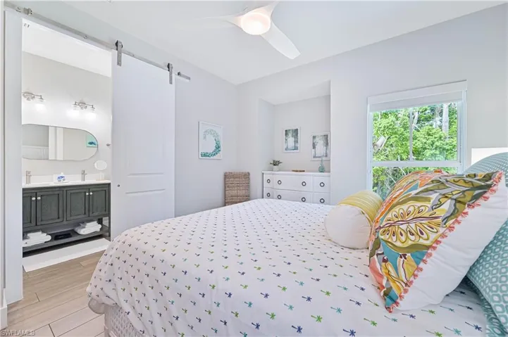 Spacious room featuring a contemporary ceiling fan, an expansive window, and a white dresser with circular hardware