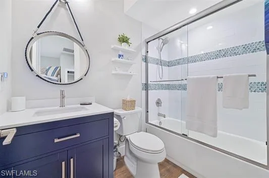 Bathroom featuring a navy blue vanity with a white countertop and undermount sink, brushed nickel faucet, and a circular mirror with rope detailing