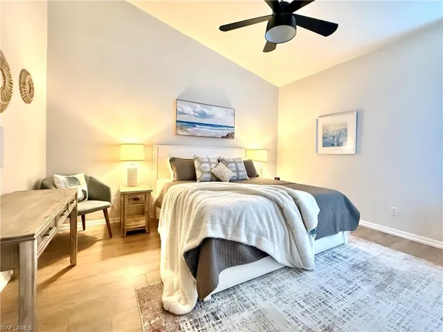 Bedroom featuring vaulted ceiling, light wood-style flooring, and ceiling fan