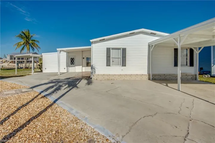 Manufactured / mobile home with concrete driveway and an attached carport
