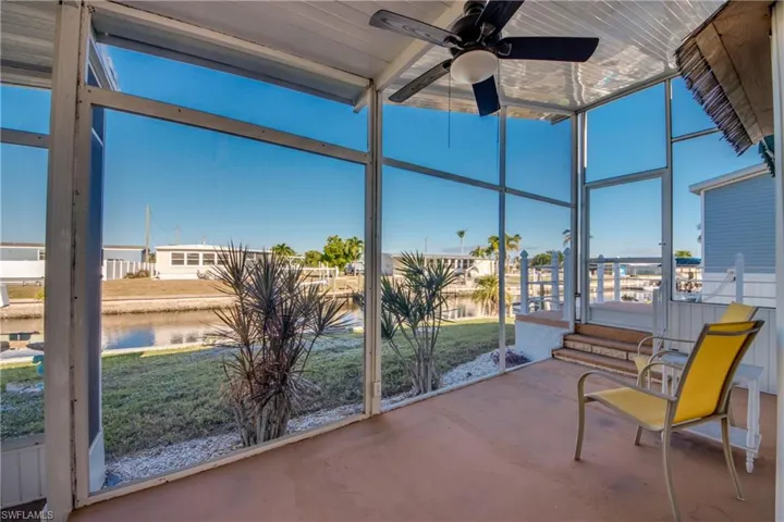 Sunroom / solarium featuring a water view, expansive windows, and concrete floors
