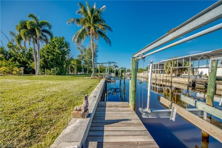 Dock featuring a water view, a yard, and boat lift
