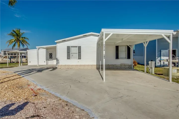 Manufactured / mobile home featuring concrete driveway and an attached carport