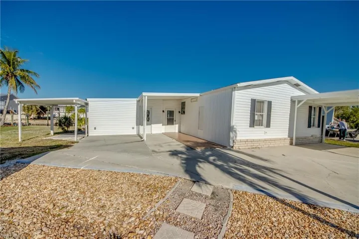 Manufactured / mobile home with concrete driveway and an attached carport