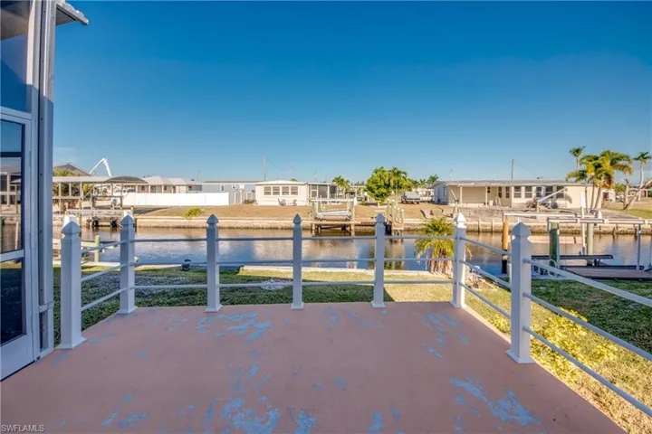 View of patio with a dock, boat lift, a water view, and a residential view