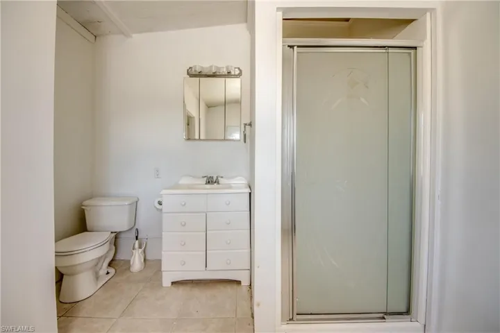 Full bathroom with vanity, a stall shower, and light tile patterned floors