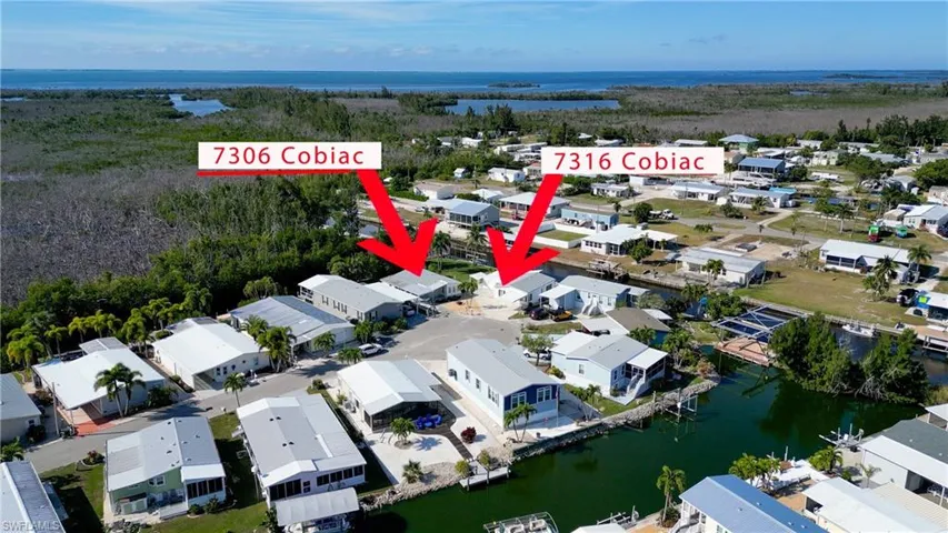Aerial view of property's location with a nearby body of water and nearby suburban area