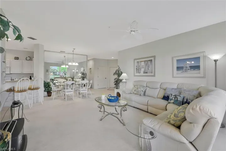 Living area with ceiling fan and light carpet