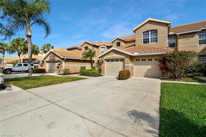 Mediterranean / spanish home featuring stucco siding, concrete driveway, a front lawn, and a tiled roof