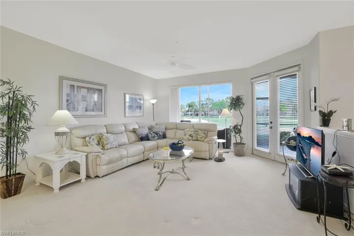 Living area with light carpet, french doors, and a ceiling fan