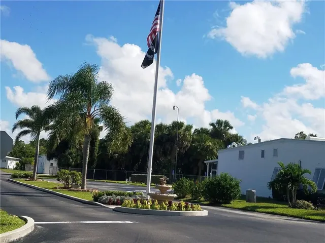 View of asphalt road featuring curbs and street lighting