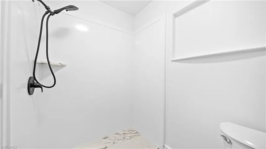 Bathroom featuring toilet and marble finish flooring
