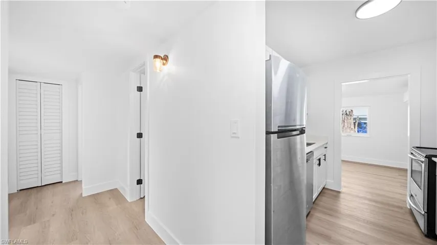 Hallway with light wood-style floors and baseboards