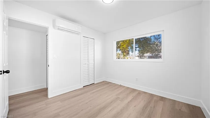 Unfurnished bedroom with light wood finished floors, a wall mounted mini split, and a closet