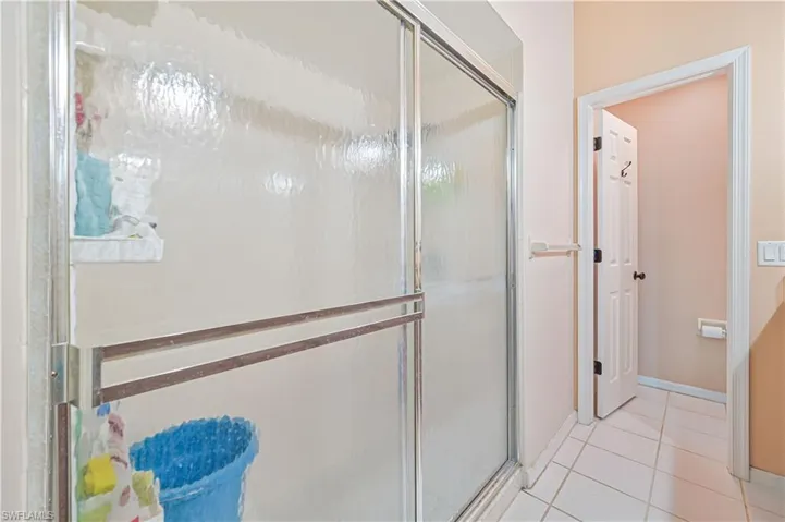 Full bathroom featuring a stall shower and light tile patterned flooring