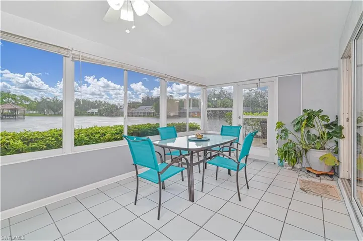 Sunroom featuring tile patterned floors and a water view