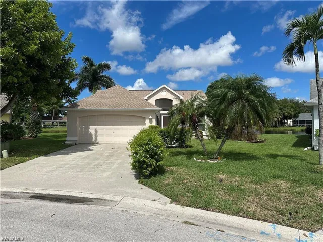 View of front of house featuring a front yard, a garage, stucco siding, concrete driveway, and a shingled roof