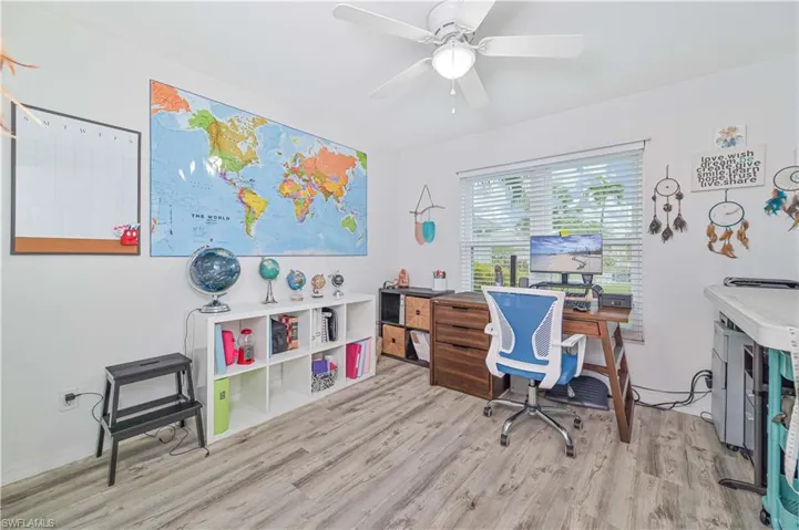 Office area with light wood-type flooring and a ceiling fan