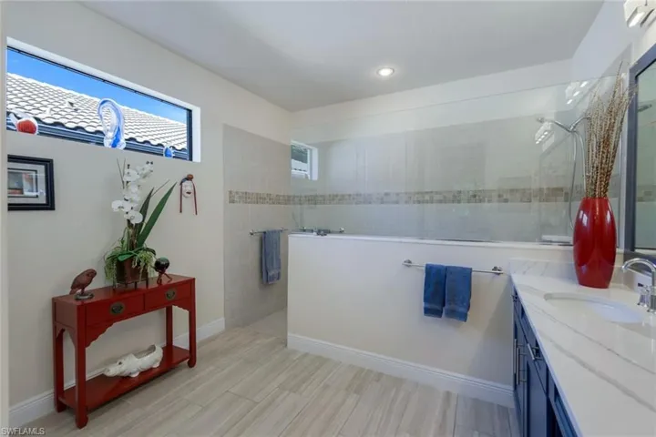 Bathroom with vanity and tiled shower