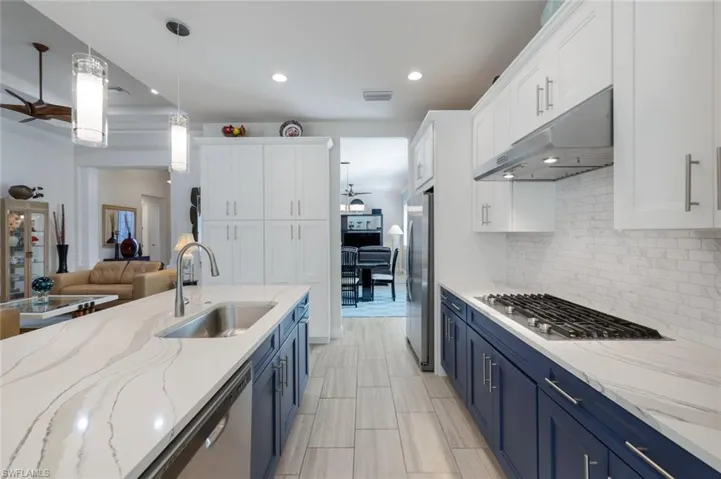 Kitchen with blue cabinets, sink, and white cabinets