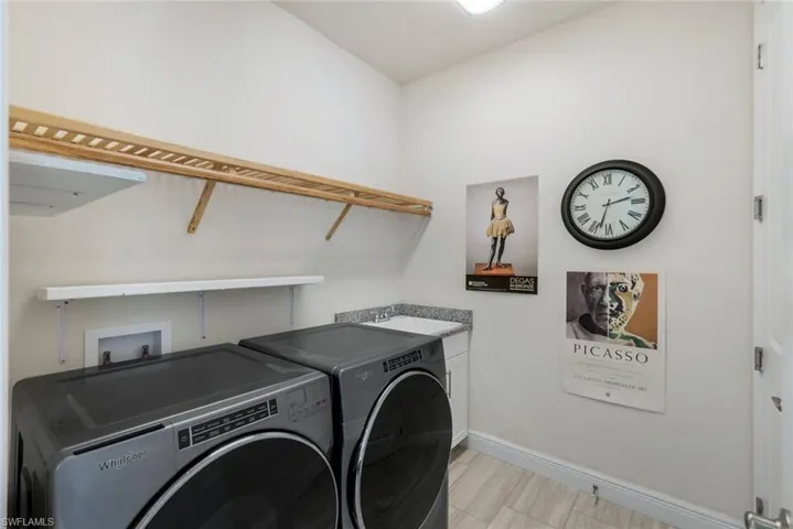 Laundry room with separate washer and dryer, sink, and cabinets