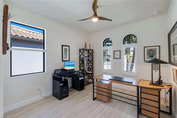 Home office with ceiling fan and light hardwood / wood-style flooring