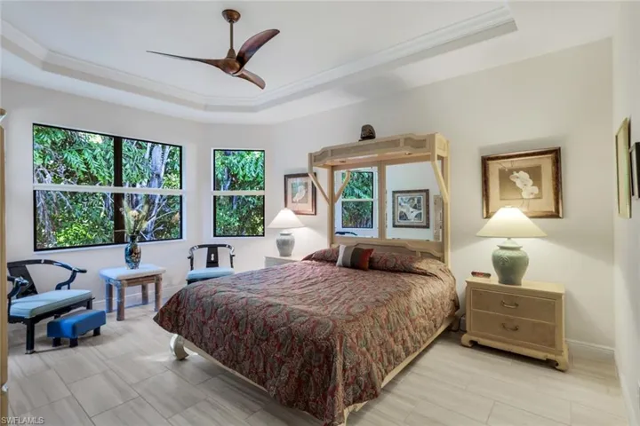 Bedroom with a tray ceiling, ornamental molding, and ceiling fan