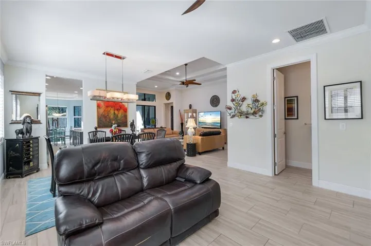 Living room featuring crown molding, light hardwood / wood-style floors, and ceiling fan