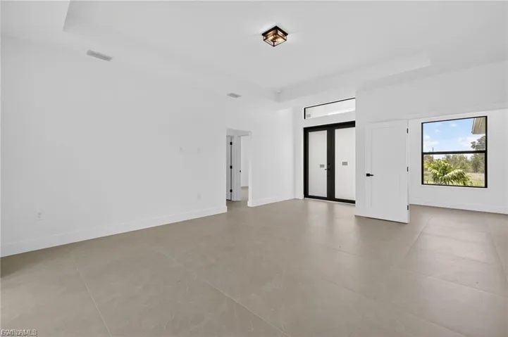 Empty room with a raised ceiling and french doors