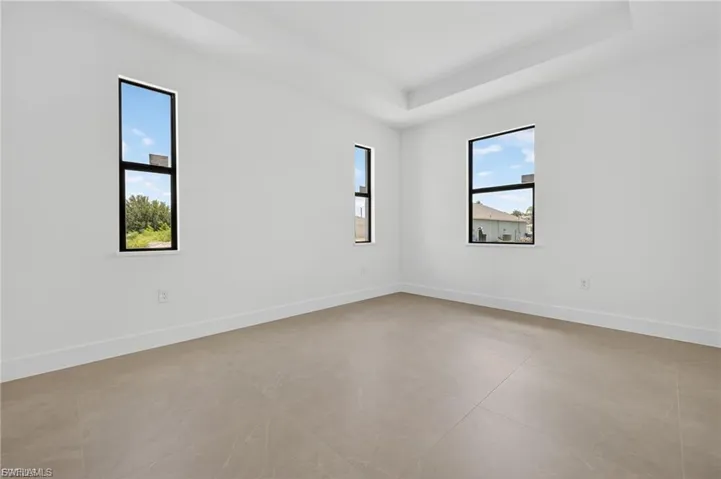 Empty room featuring plenty of natural light and a raised ceiling