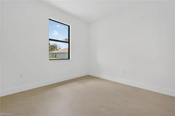 Unfurnished room featuring baseboards and concrete flooring