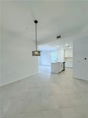 Unfurnished living room featuring a chandelier, recessed lighting, and light tile patterned flooring
