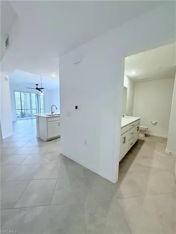 Hall featuring baseboards and light tile patterned floors