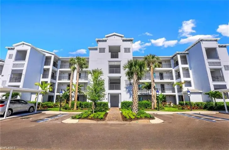View of apartment building / complex featuring uncovered parking