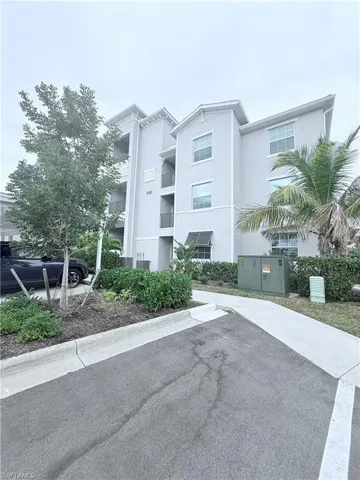 View of apartment building / complex with uncovered parking