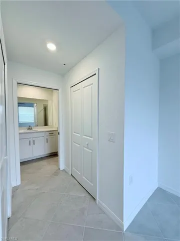 Hallway with light tile patterned flooring and recessed lighting
