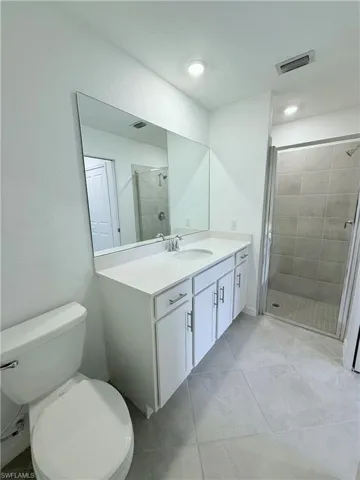 Bathroom with vanity, a stall shower, and light tile patterned floors