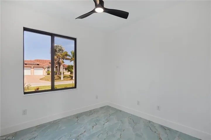 Empty room with baseboards, ceiling fan, and marble finish floor